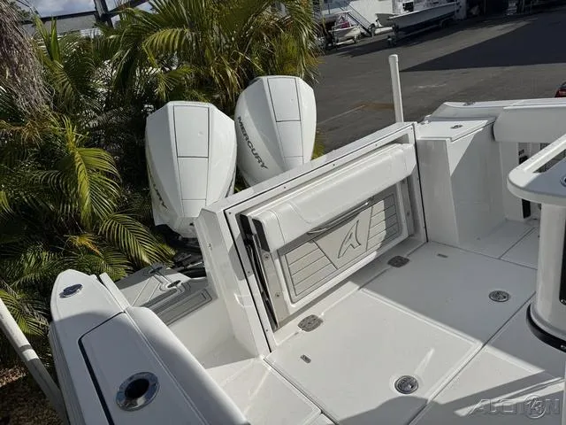 Slide: The Image of 2025 Blackfin 252CC boat deck with dual Mercury engines, surrounded by lush greenery. - 29