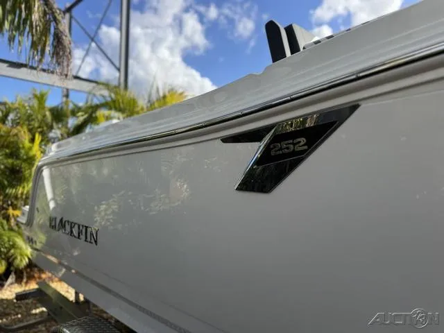 Slide: The Image of 2025 Blackfin 252CC boat side view with logo, under a clear blue sky. - 6