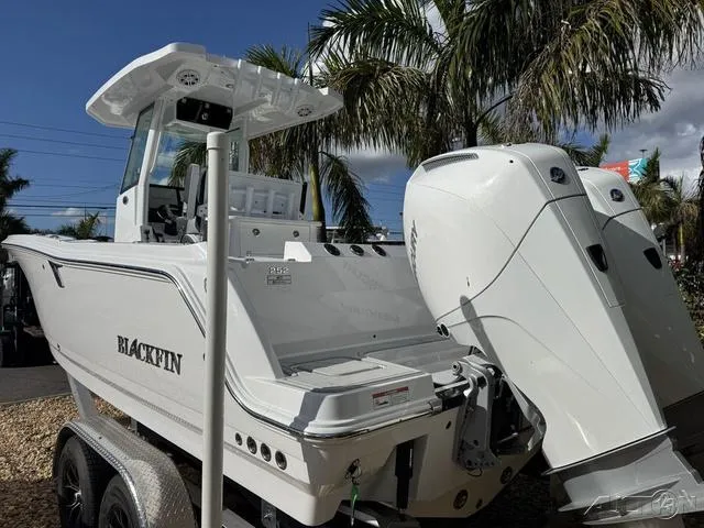 Slide: The Image of 2025 Blackfin 252CC boat with dual engines, parked under palm trees. - 8