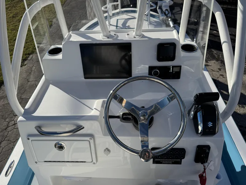 Slide: The Image of 2025 Shallow Sport 24 Sport boat dashboard with steering wheel and controls. - 12