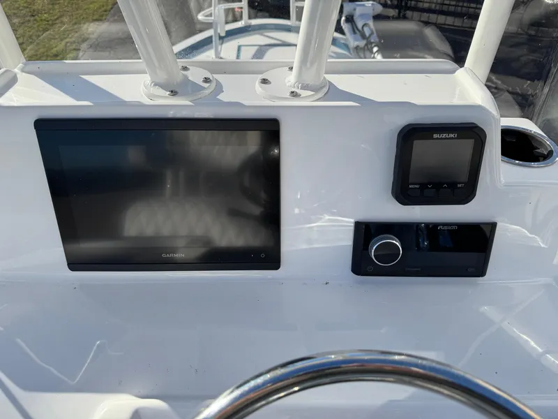 Slide: The Image of 2025 Shallow Sport 24 Sport boat dashboard with Garmin and Suzuki displays. - 13