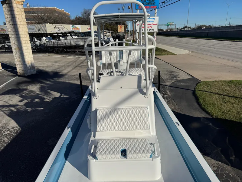 Slide: The Image of 2025 Shallow Sport 24 Sport boat with elevated seating, parked on a sunny street. - 17