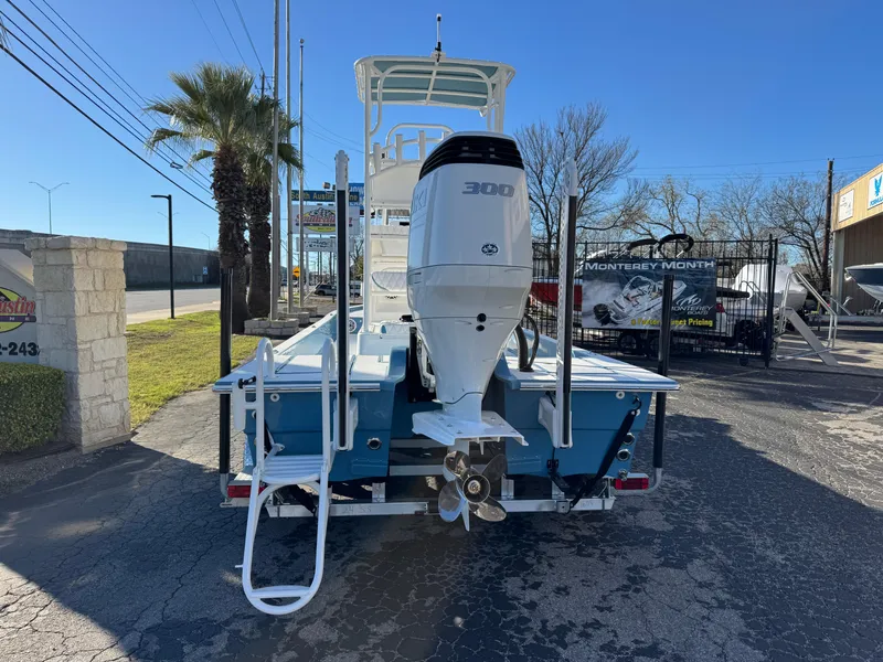 Slide: The Image of 2025 Shallow Sport 24 Sport boat with powerful outboard motor, parked outdoors. - 2