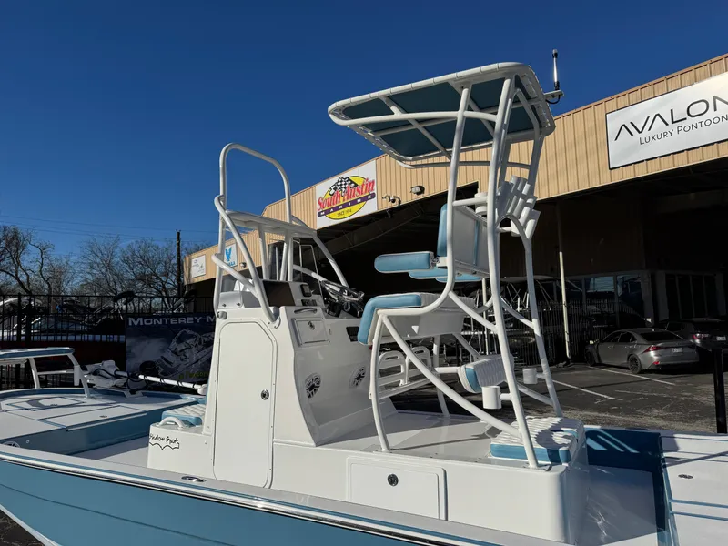 Slide: The Image of 2025 Shallow Sport 24 Sport boat with elevated seating, displayed outdoors at a dealership. - 5
