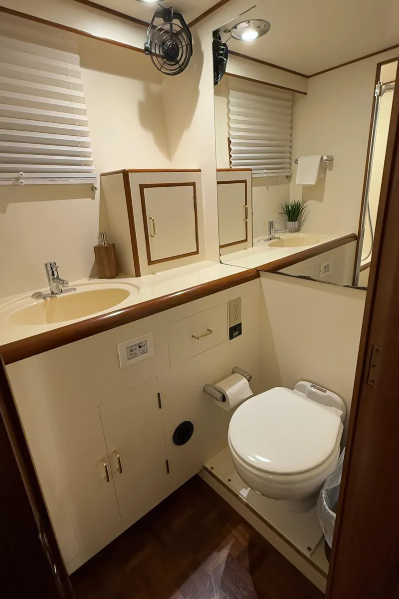 Slide: The Image of 1988 Ocean Alexander 42 CPMY yacht bathroom with sink, toilet, and storage cabinets. - 17