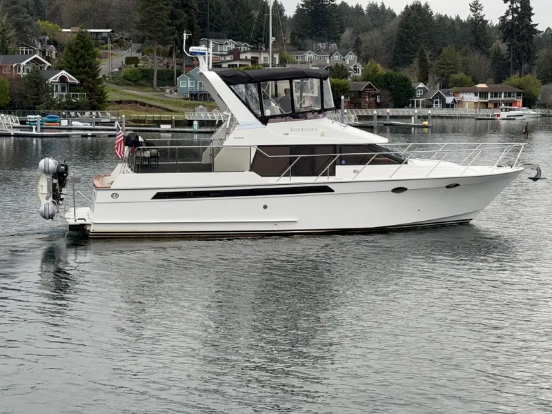 Slide: The Image of 1988 Ocean Alexander 42 CPMY yacht on calm water, surrounded by trees and houses. - 2