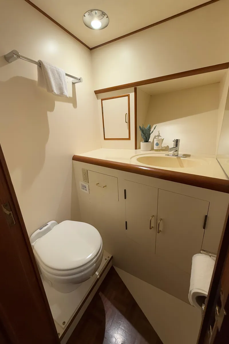 Slide: The Image of 1988 Ocean Alexander 42 CPMY yacht bathroom with sink, toilet, and storage cabinets. - 24