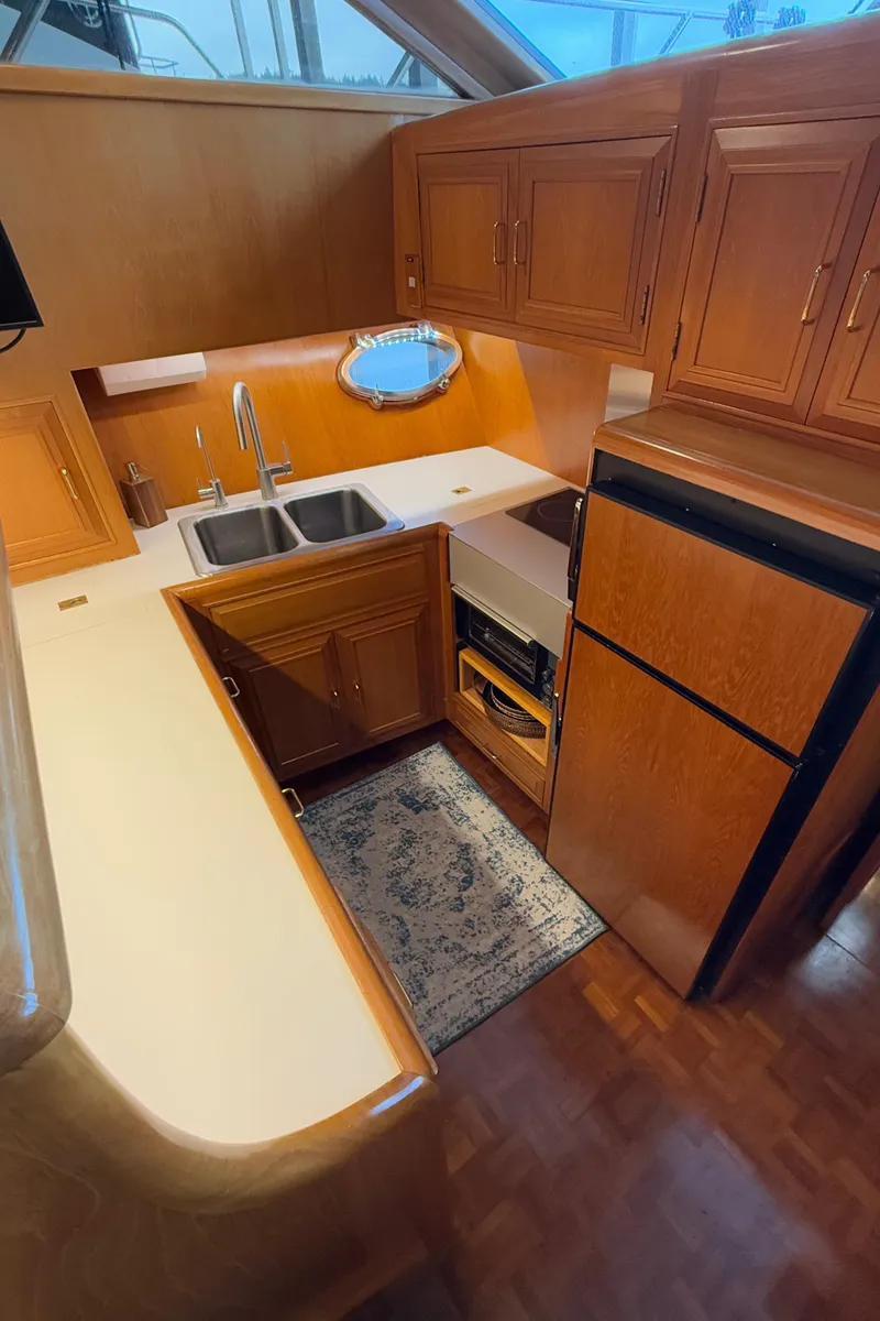 Slide: The Image of 1988 Ocean Alexander 42 CPMY yacht kitchen with wood cabinets and modern appliances. - 28