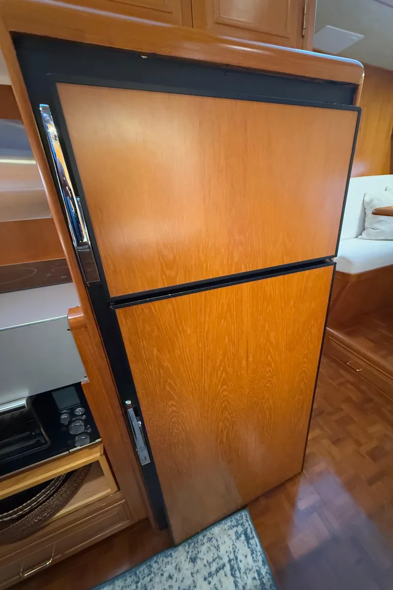 Slide: The Image of 1988 Ocean Alexander 42 CPMY yacht interior with wooden cabinetry and built-in refrigerator. - 29