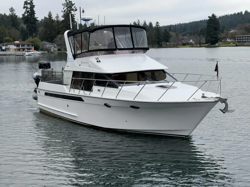 Slide: The Image of 1988 Ocean Alexander 42 CPMY yacht on a serene lake with forested shoreline. - 3