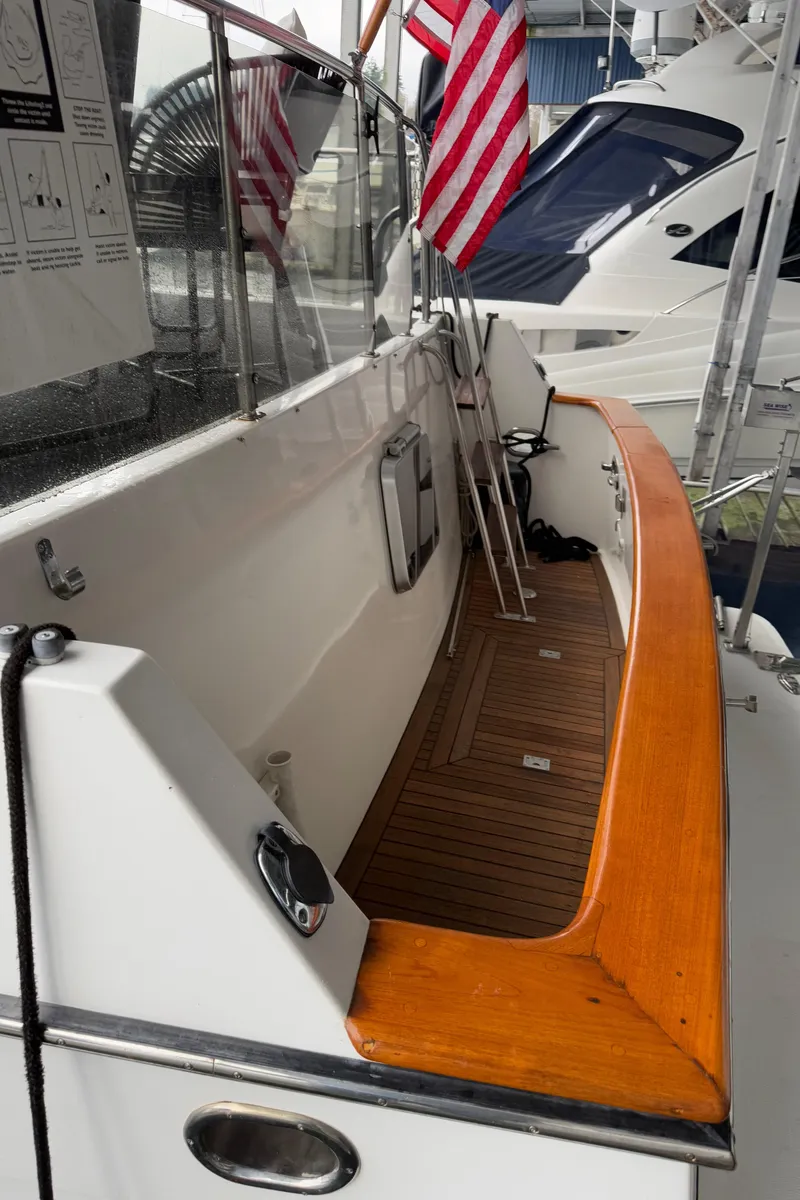Slide: The Image of 1988 Ocean Alexander 42 CPMY yacht deck with wooden trim and American flag. - 48