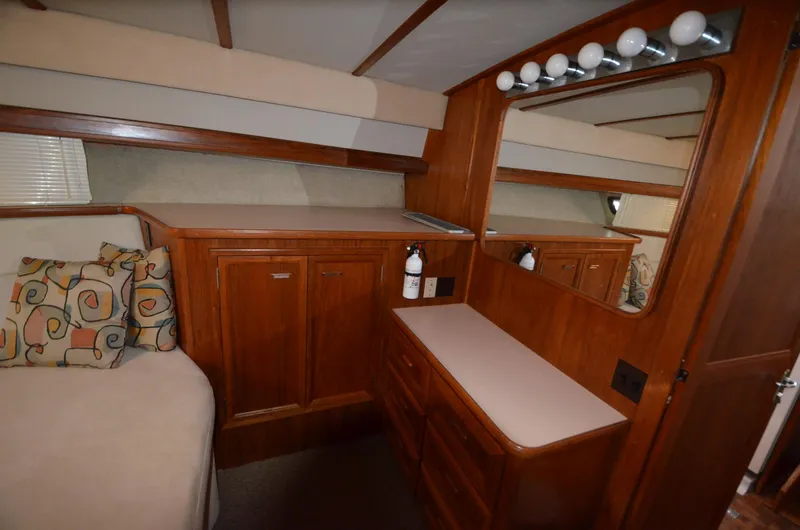 Slide: The Image of 1987 Carver 4207 yacht interior with wood cabinetry, mirror, and cushioned seating. - 13