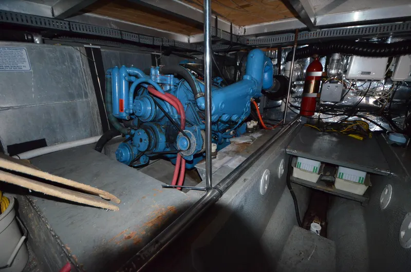 Slide: The Image of Engine room of 1987 Carver 4207 with blue engine and fire extinguisher. - 16