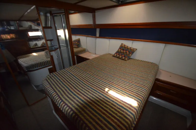 Slide: The Image of 1987 Carver 4207 yacht interior with striped bedding and wood accents. - 20