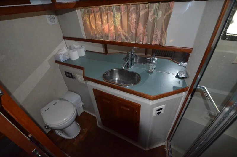 Slide: The Image of 1987 Carver 4207 bathroom with sink, toilet, and shower, featuring wood accents and floral curtains. - 22