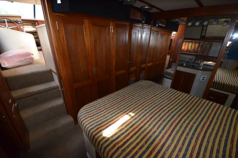 Slide: The Image of Interior of 1987 Carver 4207 yacht with wood paneling and striped bedding. - 23