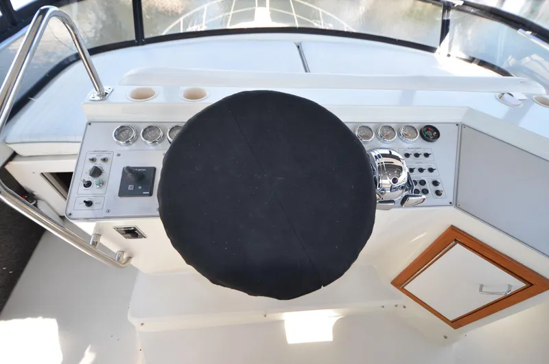Slide: The Image of 1987 Carver 4207 boat helm with covered steering wheel and control panel. - 31