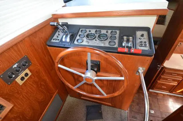 Slide: The Image of 1987 Carver 4207 boat helm with wooden steering wheel and control panel. - 34