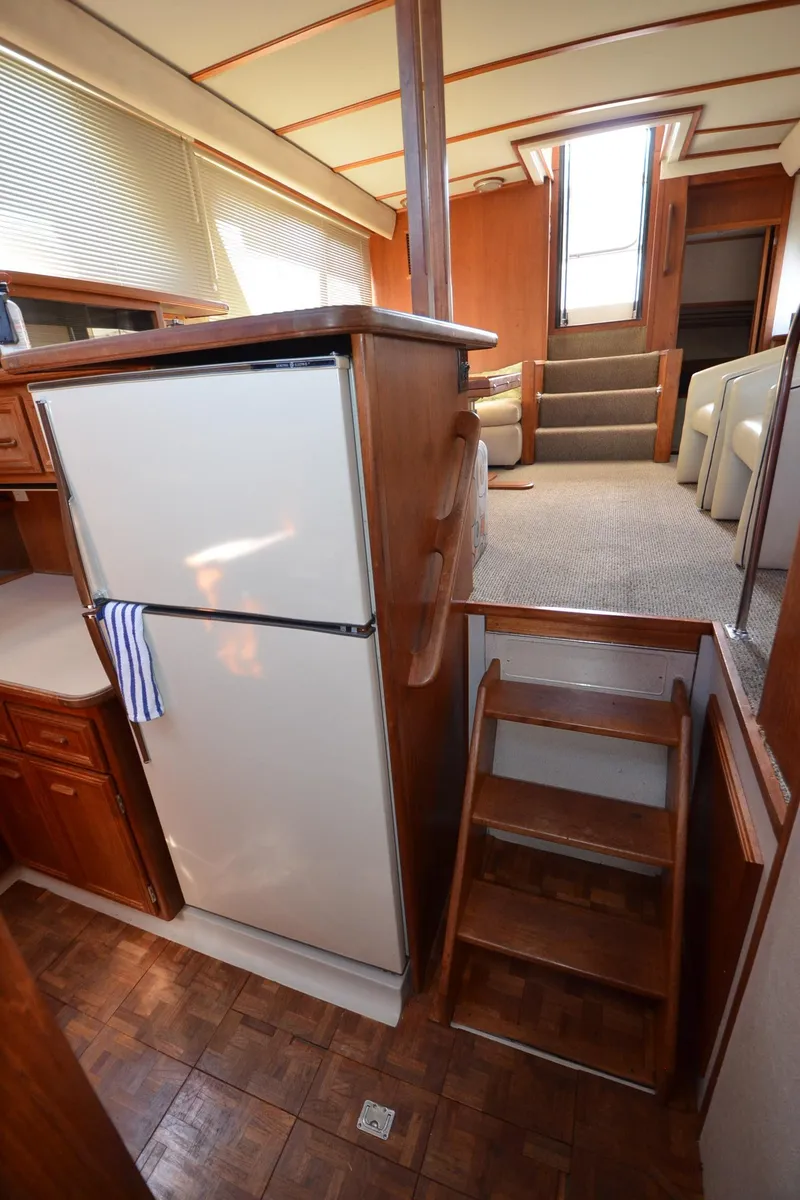 Slide: The Image of Interior of 1987 Carver 4207 yacht with kitchen and stairs, featuring wood finishes. - 37