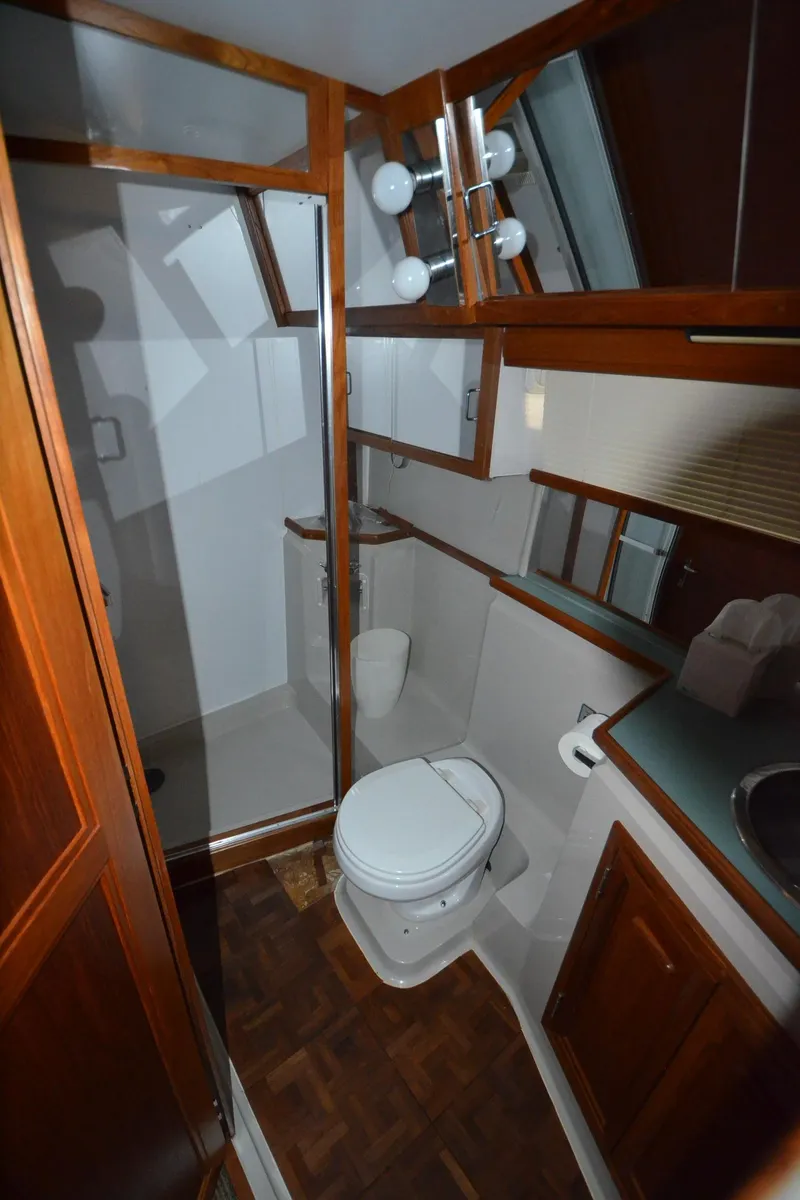 Slide: The Image of 1987 Carver 4207 yacht bathroom with wooden cabinetry, shower, and toilet. - 38