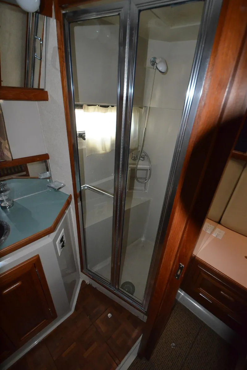 Slide: The Image of 1987 Carver 4207 yacht bathroom with shower, glass doors, and wooden cabinetry. - 39