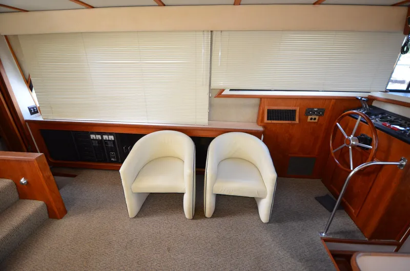 Slide: The Image of Interior of 1987 Carver 4207 yacht with white chairs and wooden helm station. - 9