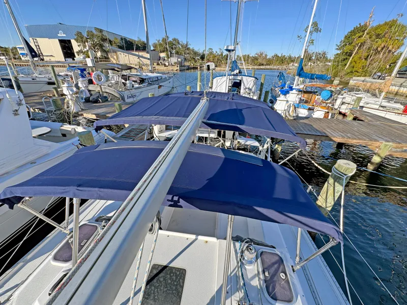 Slide: The Image of 2000 Catalina 36 MkII sailboat docked with blue canvas covers, marina background. - 42