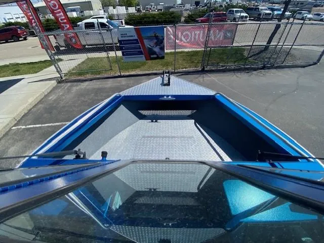 Slide: The Image of 2017 Alumaweld Intruder boat, blue interior, parked in a lot with signage and vehicles. - 12