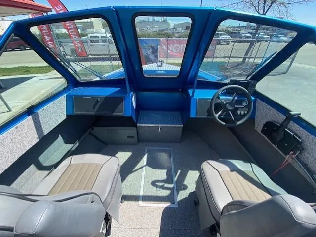 Slide: The Image of 2017 Alumaweld Intruder boat interior with blue dashboard and two seats. - 13