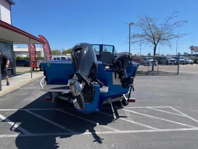 Slide: The Image of 2017 Alumaweld Intruder boat with dual outboard motors in a parking lot. - 5