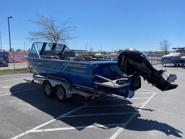 Slide: The Image of 2017 Alumaweld Intruder boat with outboard motor in a parking lot. - 6