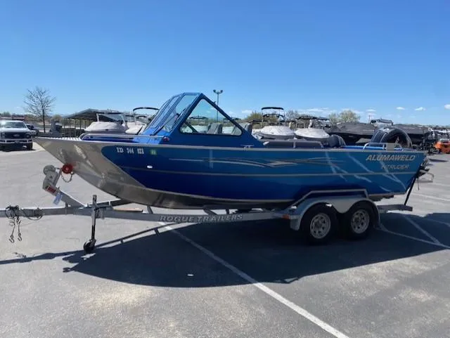 Slide: The Image of 2017 Alumaweld Intruder boat on trailer in parking lot under clear blue sky. - 7