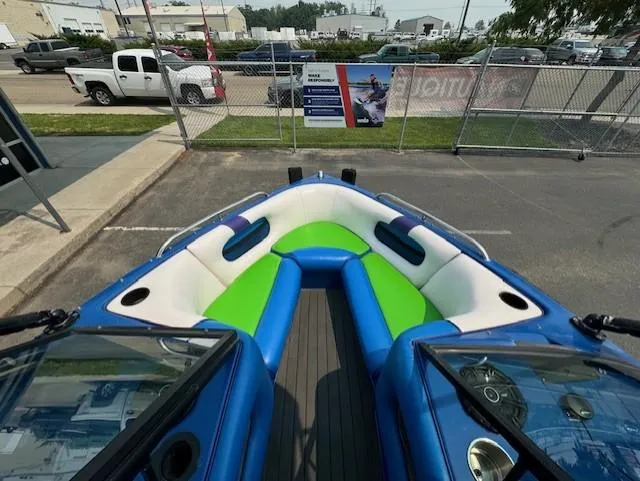Slide: The Image of 2005 Calabria Cal Air Pro-V boat interior with blue and green seating, parked outdoors. - 13