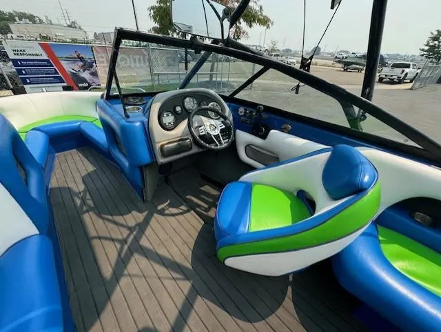 Slide: The Image of 2005 Calabria Cal Air Pro-V boat interior with blue and green seating, steering wheel, and dashboard. - 18