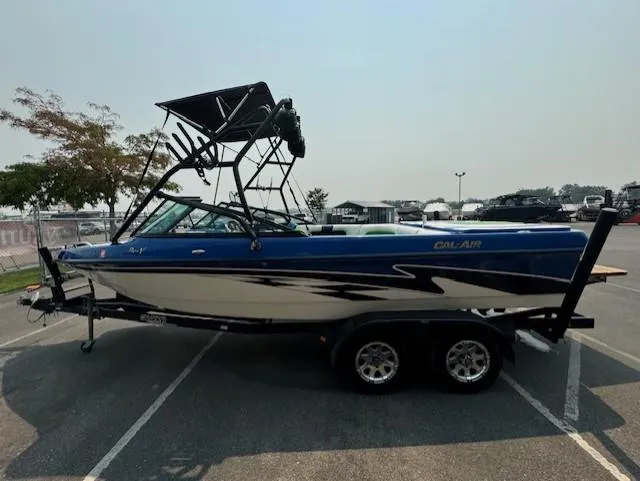 Slide: The Image of 2005 Calabria Cal Air Pro-V boat with blue and white design on a trailer in a parking lot. - 6