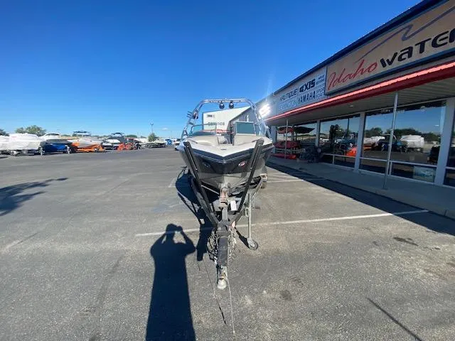Slide: The Image of 2006 Centurion Air Warrior Elite C-4 boat parked outside dealership under clear blue sky. - 4
