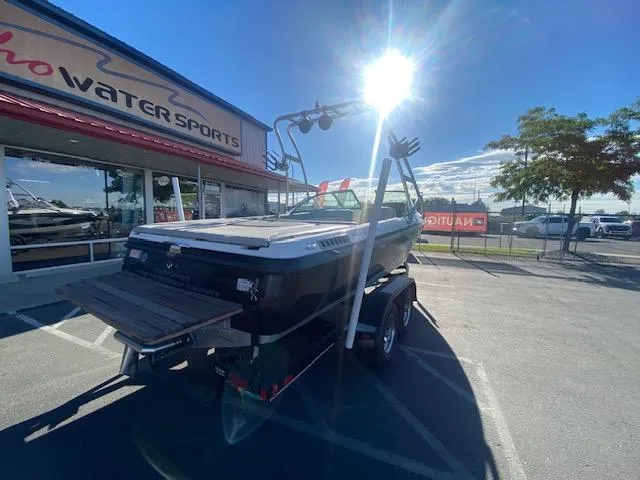 Slide: The Image of 2006 Centurion Air Warrior Elite C-4 boat on trailer outside water sports store. - 9