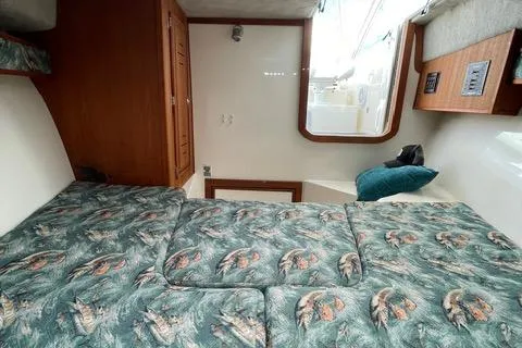 Slide: The Image of 2013 Carolina Classic 25 Express cabin interior with patterned bedding and wooden cabinetry. - 11