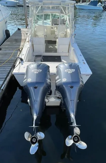 Slide: The Image of 2013 Carolina Classic 25 Express boat with twin Yamaha 250 engines docked at marina. - 16
