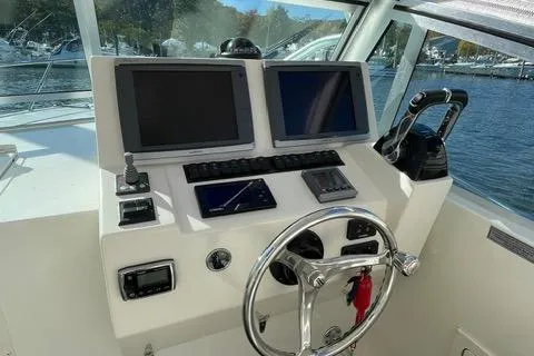 Slide: The Image of 2013 Carolina Classic 25 Express boat helm with dual screens and steering wheel. - 3