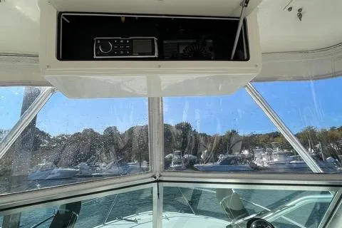 Slide: The Image of Interior view of 2013 Carolina Classic 25 Express boat with electronics and marina background. - 4