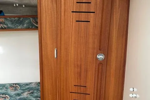 Slide: The Image of 2013 Carolina Classic 25 Express cabin interior with wooden door and patterned upholstery. - 9