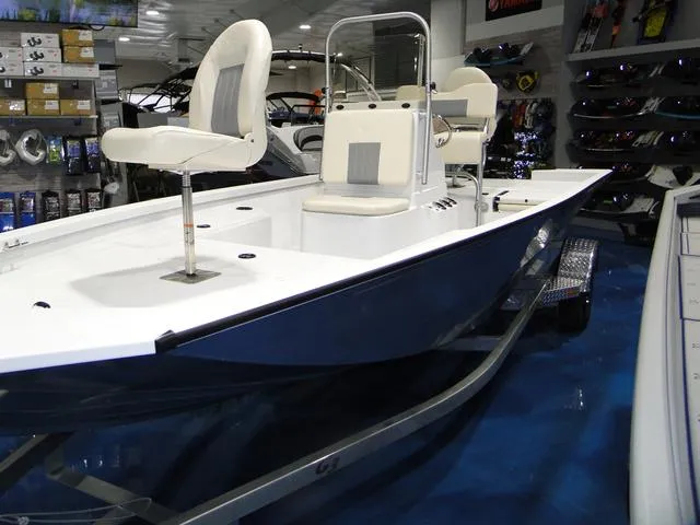 Slide: The Image of 2024 G3 Bay 18 GX boat displayed in showroom with white seating and sleek design. - 1
