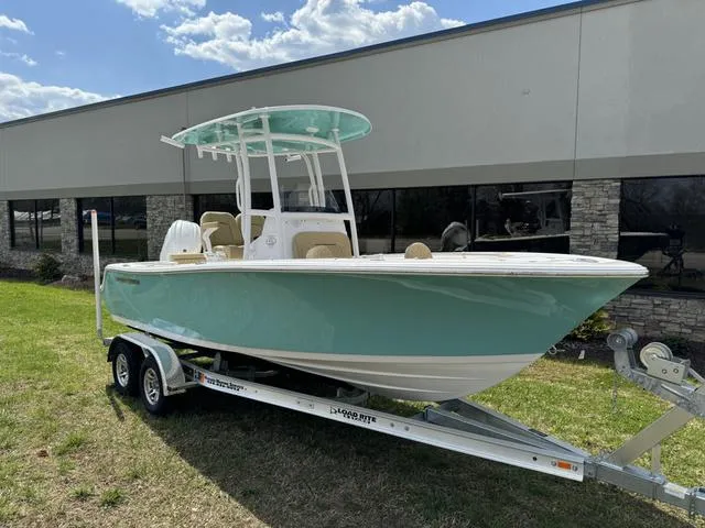 Slide: The Image of 2024 Sportsman Open 212 boat on trailer, parked outdoors, under a partly cloudy sky. - 1