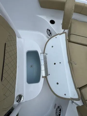 Slide: The Image of 2024 Sportsman Open 212 boat interior with tan seating and storage compartment. - 11