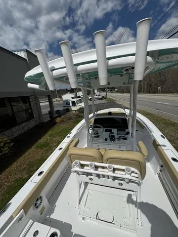 Slide: The Image of 2024 Sportsman Open 212 boat with T-top and dual seats, parked outdoors. - 3