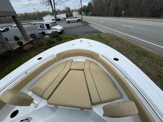Slide: The Image of 2024 Sportsman Open 212 boat with tan seating, parked near a road. - 6