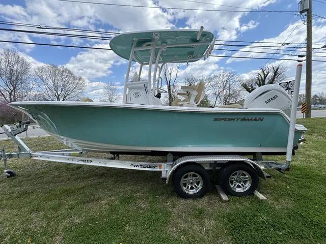 Slide: The Image of 2024 Sportsman Open 212 boat on trailer, light blue hull, parked on grass. - 9