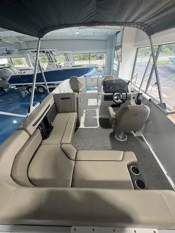 Slide: The Image of 2024 Hurricane FunDeck 1960 REF boat interior with seating and steering wheel in showroom. - 12
