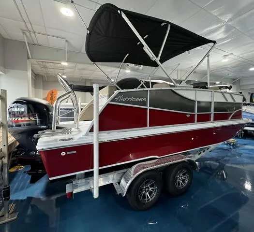 Slide: The Image of 2024 Hurricane FunDeck 1960 REF boat with canopy, displayed indoors on a trailer. - 3